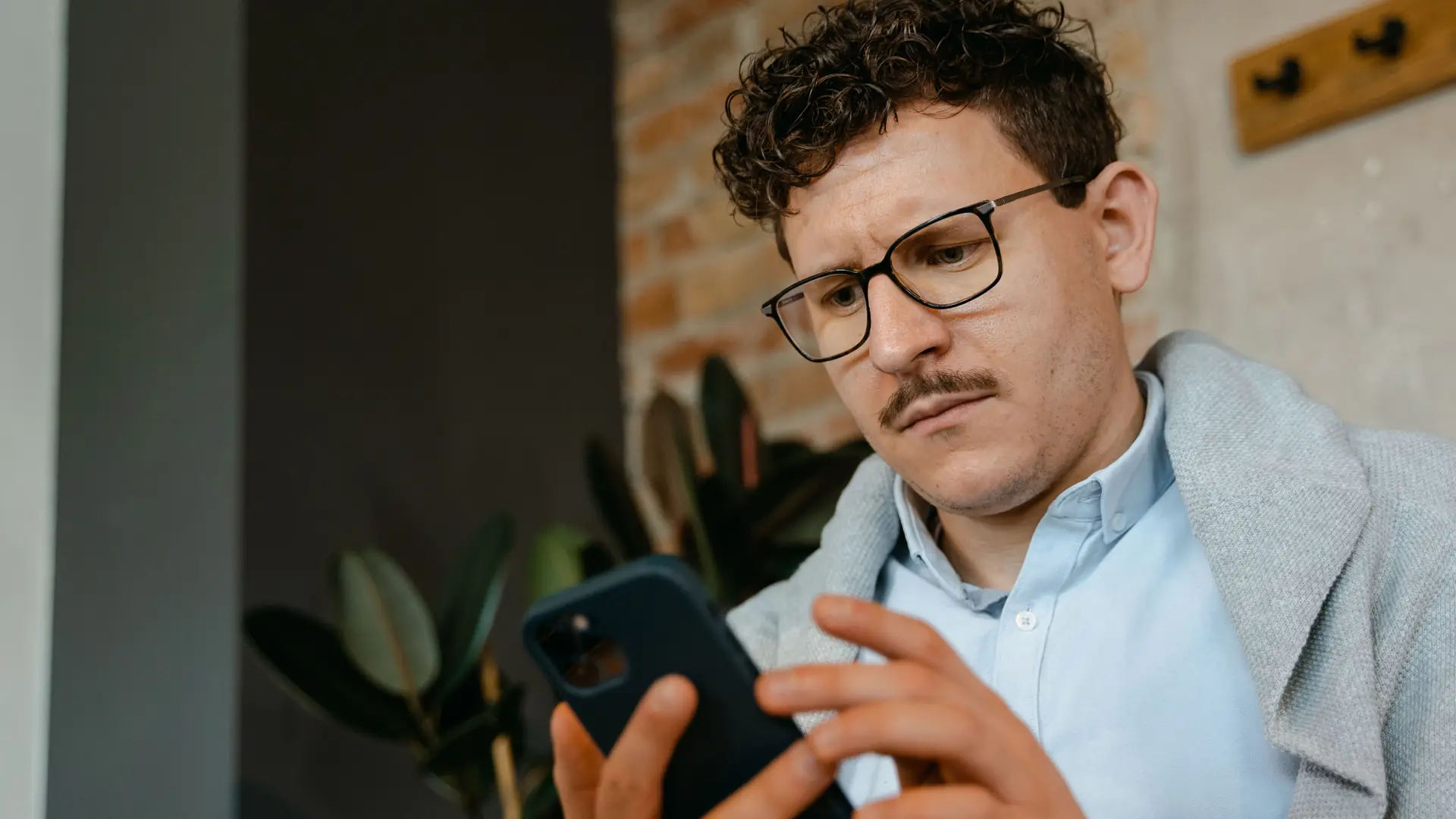Business owner looking concerned while reading a review on his phone