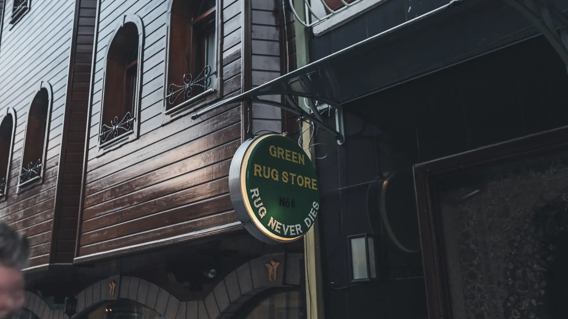City street with a wooden storefront and a hanging business sign