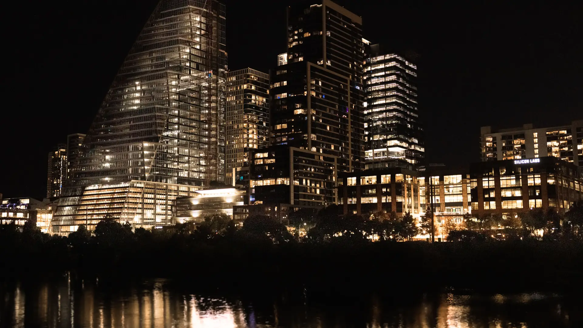 Austin skyline lit up at night and reflected in the river